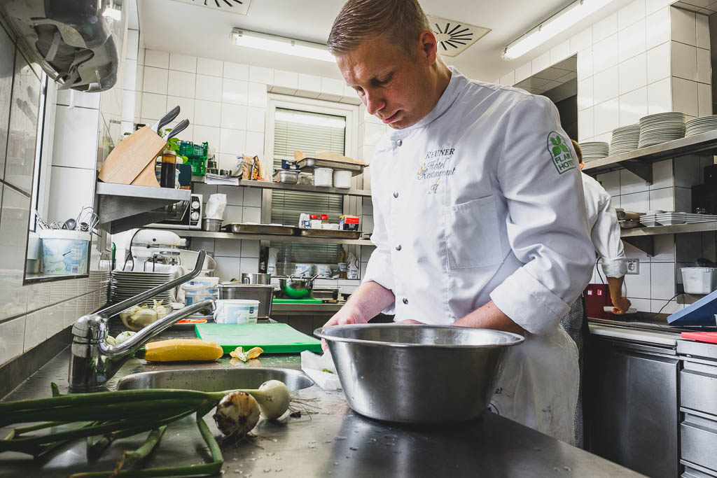 Daniel Reuner bereitet Schüttelzucchini und Schüttelkohlrabi mit frischem Salat aus dem Garten in der Küche des Flair Hotel Reuner zu
