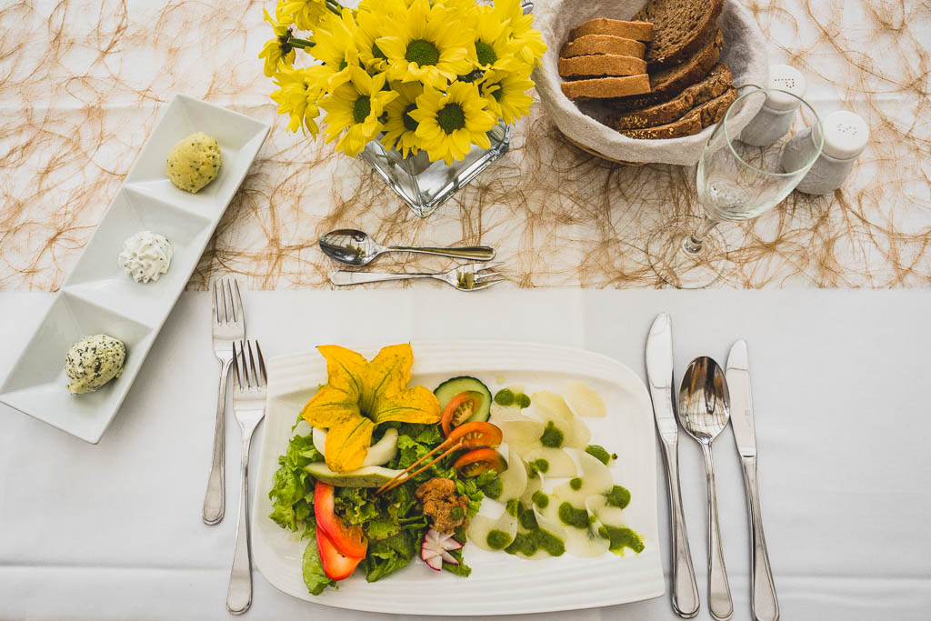 gedeckter Tisch im Restaurant des Flair Hotel Reuner mit Schüttelzucchini und Schüttelkohlrabi mit frischem Salat aus dem Garten